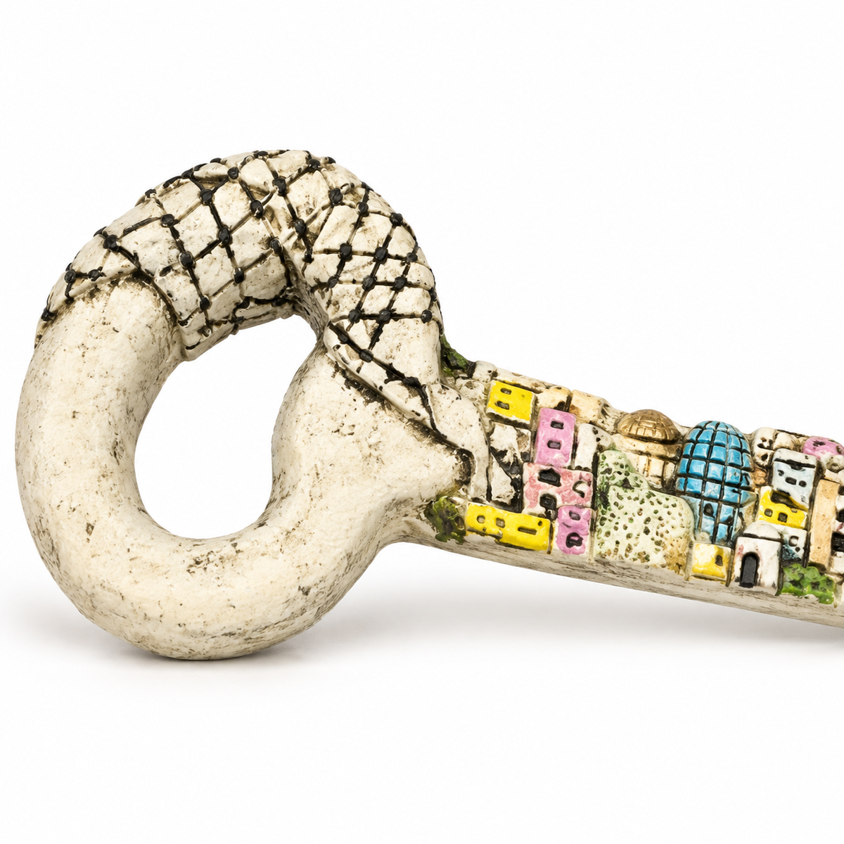 Visible keffiyeh-patterned loop and colorful cityscape shaft of a cream-tone decorative key.