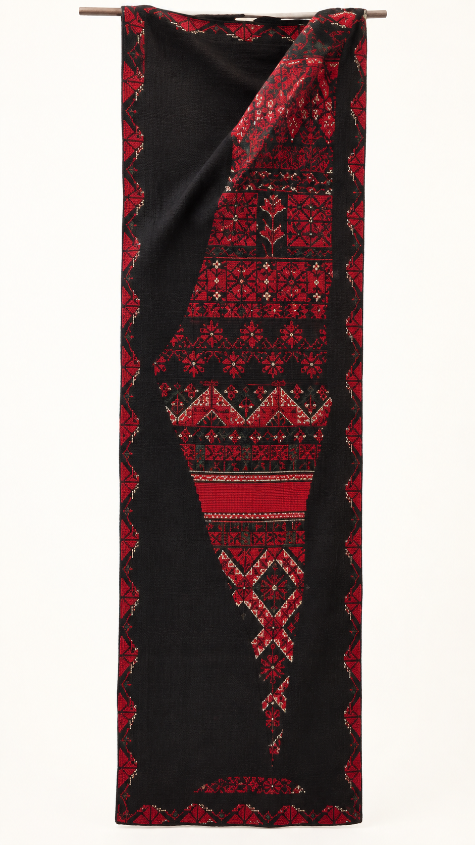 Red geometric embroidery on a long black textile panel.