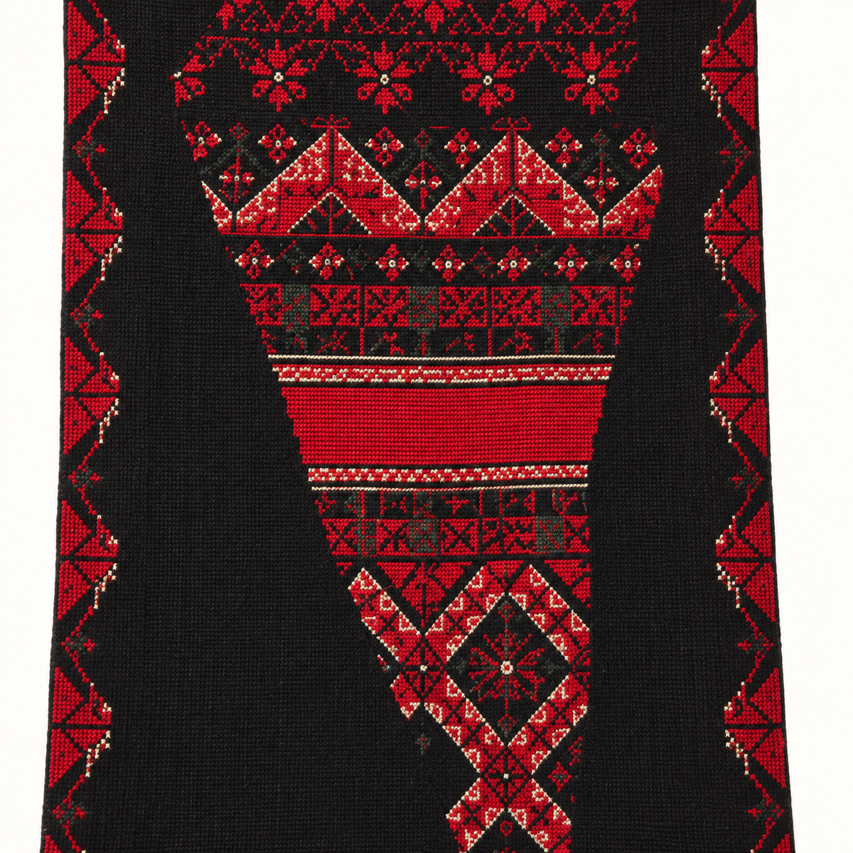 Detail of the red geometric embroidery and black textile.